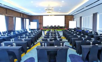 a large conference room filled with rows of tables and chairs , ready for a meeting or event at Forbis Hotel