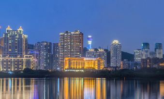 A city at night with a illuminated skyline reflecting on the water in front at Marco Polo Xiamen