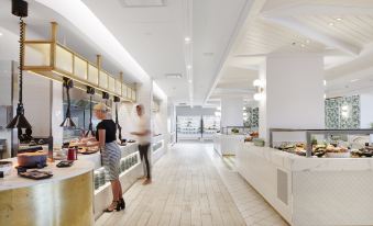 a modern kitchen with white marble countertops and wooden floors , featuring various appliances and utensils at The Ville Resort - Casino