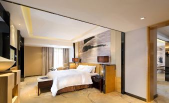The middle room features a large bed with a stylish wallpaper accent and wooden furnishings at Tianyuan Hotel