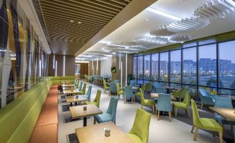 The restaurant features spacious indoor seating and large windows, with tables positioned in the center at Holiday Inn Express Hangzhou East Station
