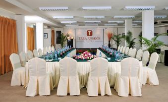 a conference room set up for a meeting , with tables and chairs arranged in a semicircle at Tara Angkor Hotel