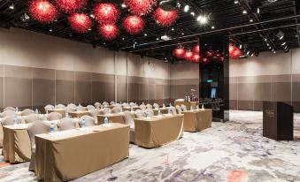 a conference room set up for a meeting , with tables and chairs arranged in rows at Hotel Valletta