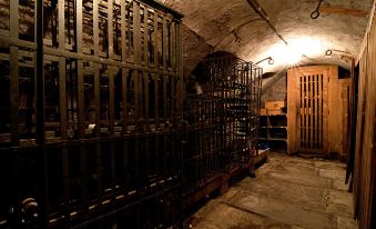 a wine cellar with multiple racks of wine bottles and wine glasses , as well as some bottles on display at Hotel-Restaurant Bären