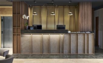 The hotel lobby features a front desk and reception area with wood paneling on both sides at NH Logrono Herencia Rioja
