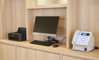 A computer desk is mounted with a wooden shelf above it, which holds a monitor, keyboard, and mouse at Sotetsu Fresa Inn Osaka Namba