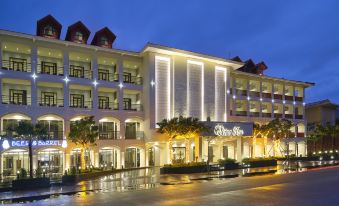 "a large white building with a sign that reads "" royal palm "" is surrounded by trees and lights" at Senna Hue Hotel