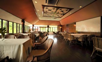 a large dining room with wooden tables and chairs arranged for a group of people to enjoy a meal together at Paya Beach Spa & Dive Resort