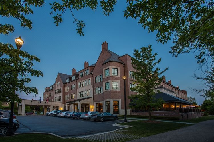 a brick building with a parking lot in front of it , where several cars are parked at Royal Park Hotel