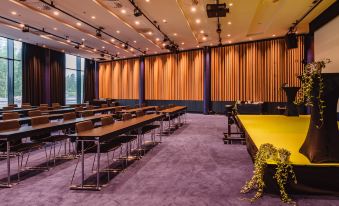 An auditorium is a large conference room with rows of tables and chairs along the far wall at Clarion Hotel Aviapolis