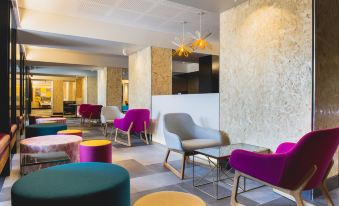 a modern office space with various seating options , including couches and chairs , as well as a reception area at Metro Hotel Perth