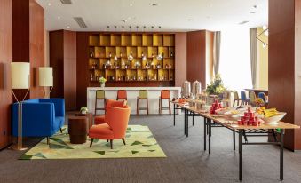 There is an open concept dining area in the middle of the room, furnished with tables and chairs at Hampton by Hilton Ji'an