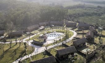 aerial view of a village surrounded by trees , with a large circular fountain in the center at Alba Wellness Valley by Fusion