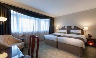The top floor of the hotel features a bedroom with double beds, large windows, and a table in the middle at Marco Polo Hongkong Hotel