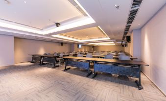 a large conference room with multiple rows of chairs arranged in a semicircle around a long table at Hengxing Mercure Hotel