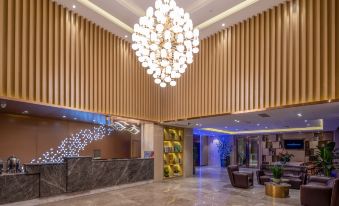 The modern lobby is adorned with a large chandelier and a wood-paneled ceiling at Century Garden Hotel