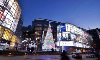 At night, the city's main building and its reflection in front create a striking sight at Motel Hotel (Shanghai Changping Road Metro Station)