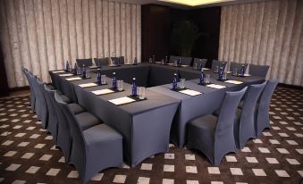 A spacious conference room is arranged with long tables and chairs for hosting events or private meetings at Boyue Hotel Shanghai Air China Hongqiao Airport