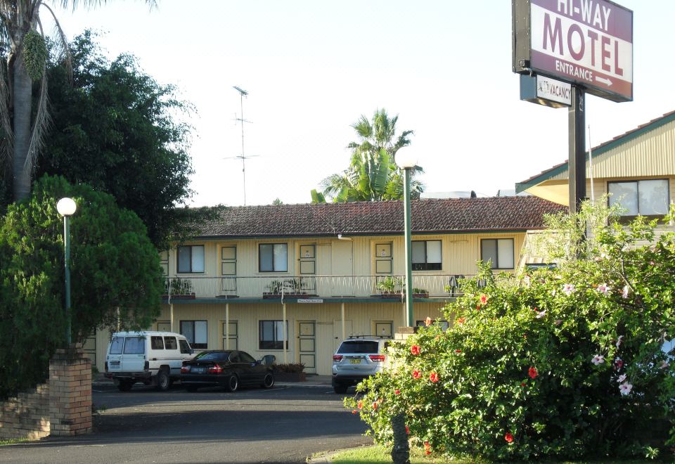 "a brick building with a sign that reads "" henry motel "" in front of a parking lot" at Hi-Way Motel Grafton - Contactless