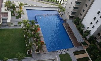 An overhead view reveals a spacious swimming pool surrounded by loungers and other amenities at Covillea Bukit Jalil Room