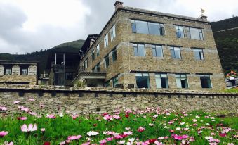 An old building behind a large field with flowers has been converted at Hotel Blanche