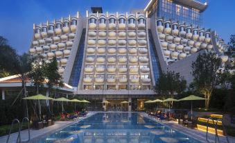 The hotel's exterior view at night, featuring a pool in front at Hilton Shenzhen Shekou Nanhai