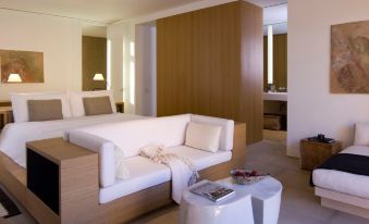 a modern bedroom with a white couch , a bed , and a small table in the corner at Amangiri