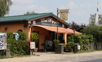 "a restaurant with a sign that says "" restaurants pizzeria "" in front of it , located on a dirt road" at Falkensee