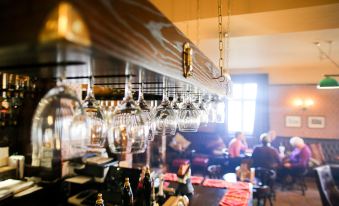 a bar with numerous wine glasses hanging from the ceiling , creating an inviting atmosphere for patrons at The Red Lion
