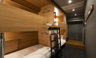There is another bedroom with two bunk beds and an overhead bed in the middle on top at Grids Tokyo Ueno Hotel&Hostel