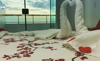 a white bed with two swans made of towels , creating a romantic atmosphere in a hotel room at Sophia 2 Residence Inn