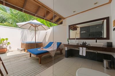 a small outdoor area with a blue lounge chair , an umbrella , and a sink , under a wooden canopy at Vilamendhoo Island Resort & Spa