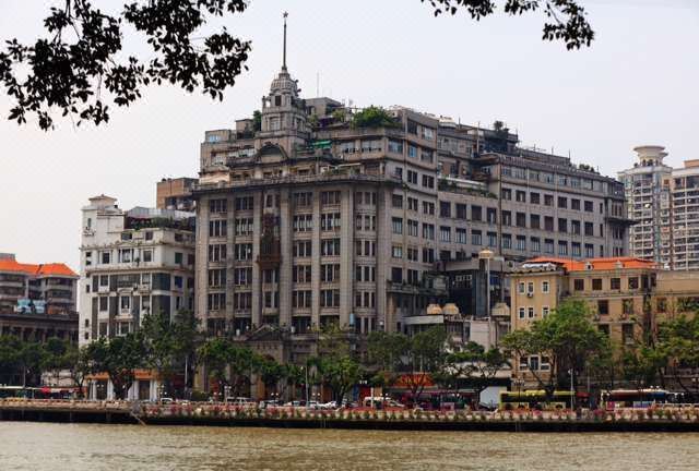 The Bund is a scenic area with stunning buildings on both sides and a few pedestrians strolling along at Na Fang Da Sha Hotel