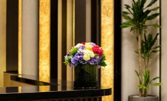 There is a table with flowers in front and an office area behind the reception desk, which is spacious at Burlington Hotel