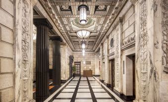 The lobby of a building with large windows on both sides features an ornate ceiling at Pacific Hotel