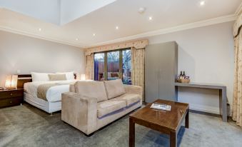 a modern bedroom with a large bed , couch , and wooden coffee table in the living room at Seymours on Lydiard