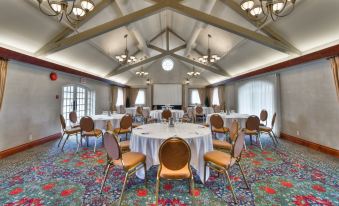a large room with tables and chairs set up for a meeting or event , with a projector screen on the wall at St. Eugene Golf Resort & Casino