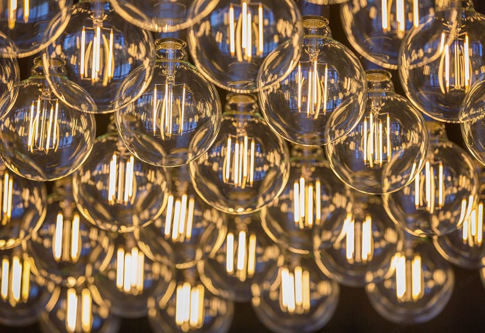 a close - up view of a large number of dimly lit light bulbs hanging from the ceiling at Sage Melbourne Ringwood