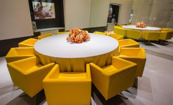 The meeting room is furnished with yellow chairs and a round table in the center, all surrounded by white panels at Jinjiang Inn (Shanghai People's Square East Huaihai Road)