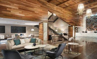 a modern living room with a wooden ceiling , a couch , and several chairs arranged around it at Pan Pacific Melbourne