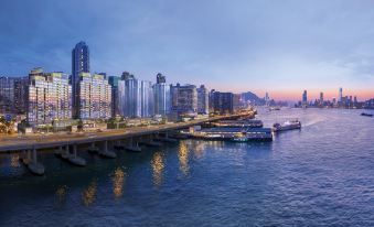 In front of the city skyline and buildings, there is an elevated bridge at Hyatt Centric Victoria Harbour Hong Kong