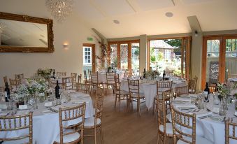 a well - decorated dining room with white tablecloths , chairs , and a chandelier hanging from the ceiling at The Durham Ox