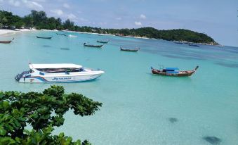 a beautiful beach scene with several boats floating in the water , creating a picturesque atmosphere at Chareena Hill Beach Resort