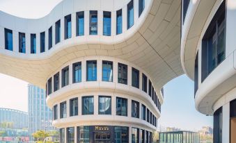 The exterior and facade of the building have a modern design, featuring large windows on both sides at MUYI Hotel Hongqiao Hub Shanghai