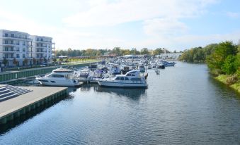 a marina filled with boats of various sizes , including luxury yachts , docked along the shore at Quellenhof