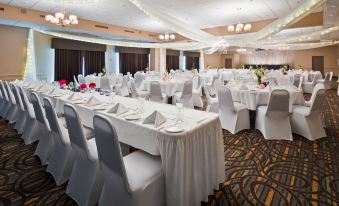 a large banquet hall with multiple white tables and chairs set up for a formal event at Best Western Pembroke Inn  Conference Centre