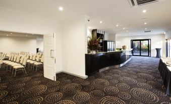 a modern hotel lobby with a black and white checkered floor , a reception desk , and several chairs at Mission Beach Resort