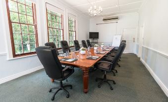 a large conference room with a wooden table surrounded by chairs and a television mounted on the wall at The Cellars-Hohenort