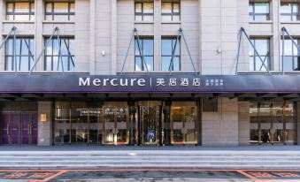 "a large hotel entrance with a sign that reads "" mercure "" prominently displayed on the building" at Hengxing Mercure Hotel