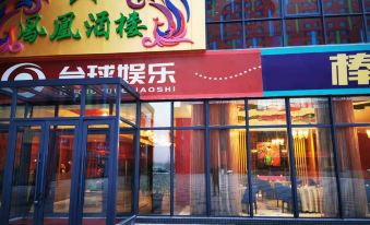 a brightly lit restaurant with a colorful sign , located in a shopping mall or a shopping center at Ximei Lucky Hotel